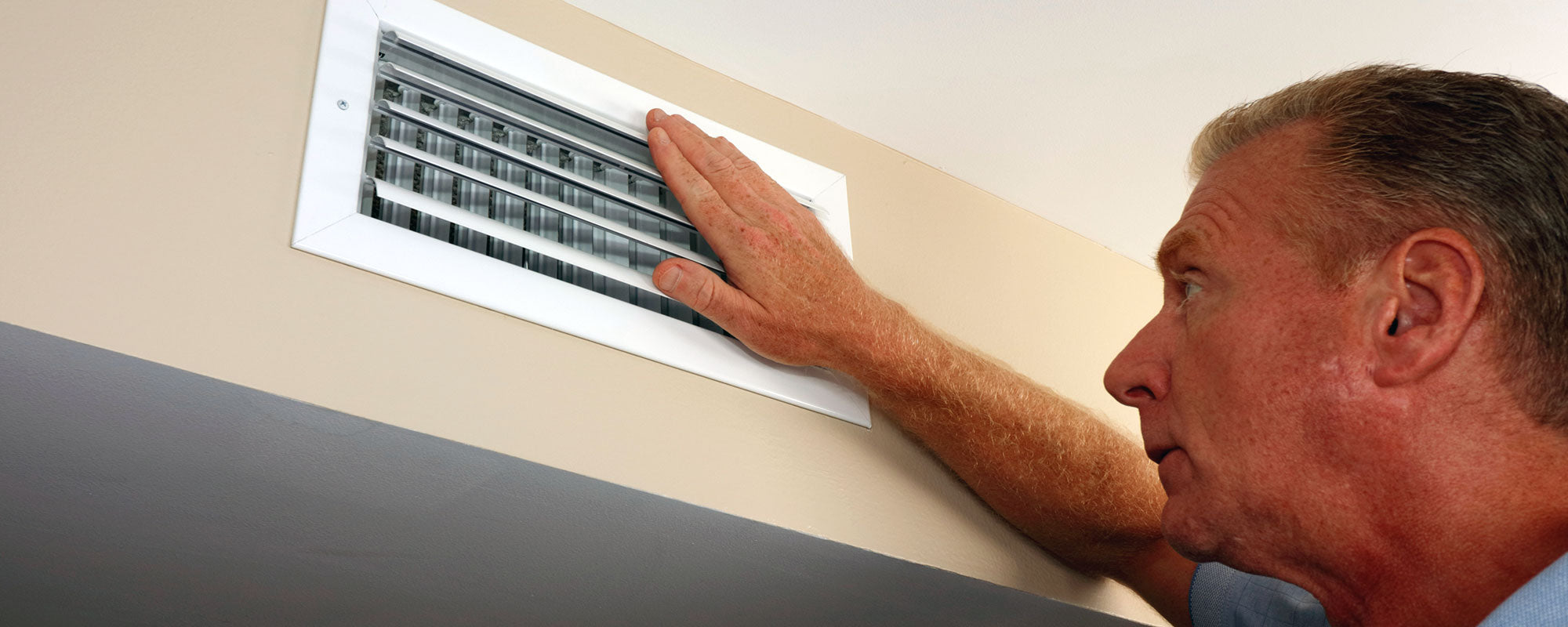 older man feeling vent and wondering Why Is My Furnace Blowing Cold Air