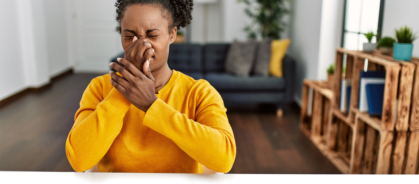 african american woman holding her nose because of vinegar odors caused by air conditioner