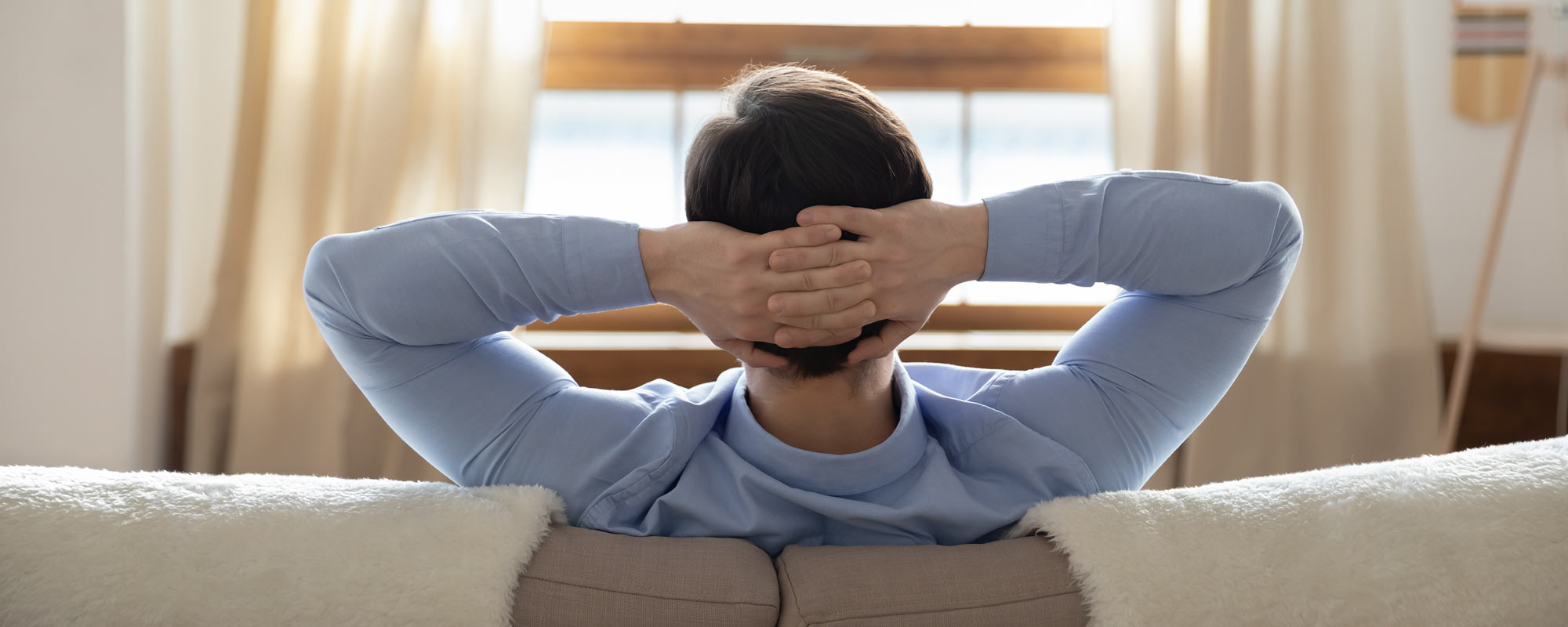 man relaxing on couch enjoying whole house humidifier