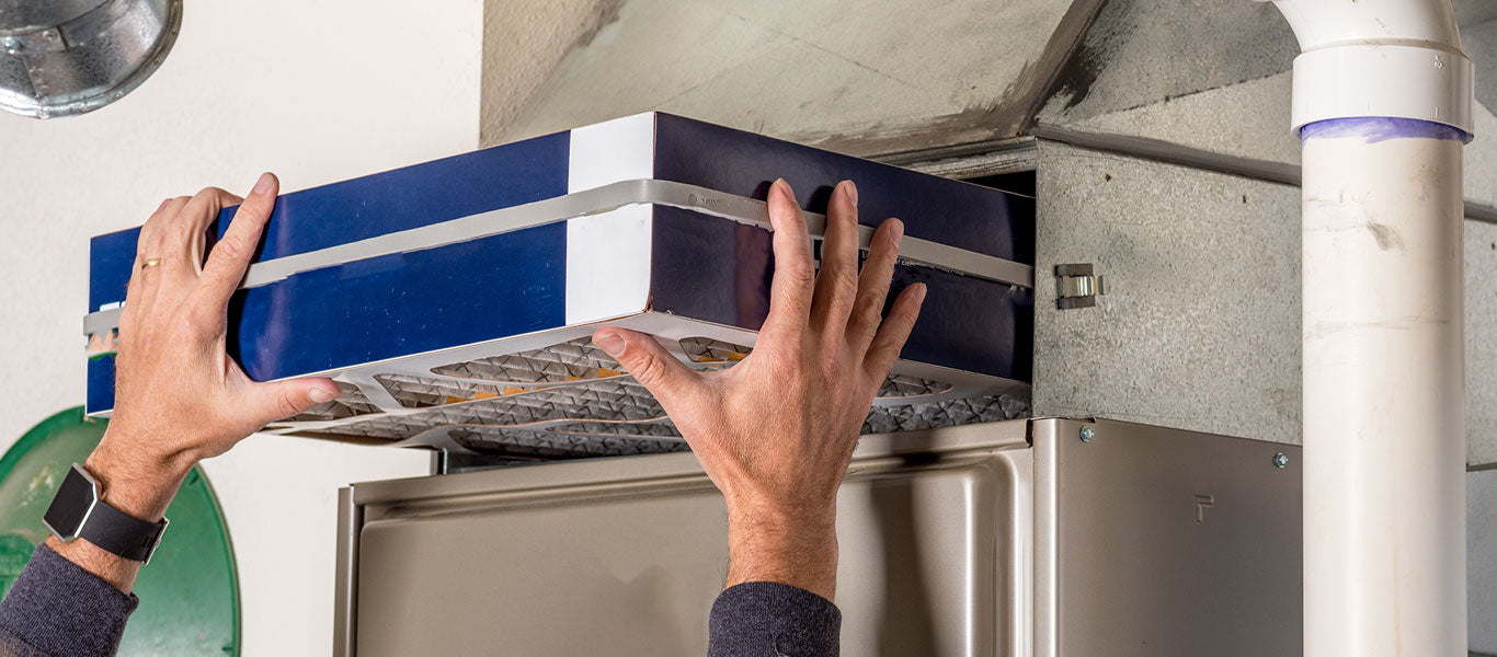 man replacing MERV 8 filter from HVAC system in home