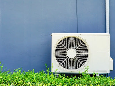 mini split air conditioner outside against a blue exterior wall of house